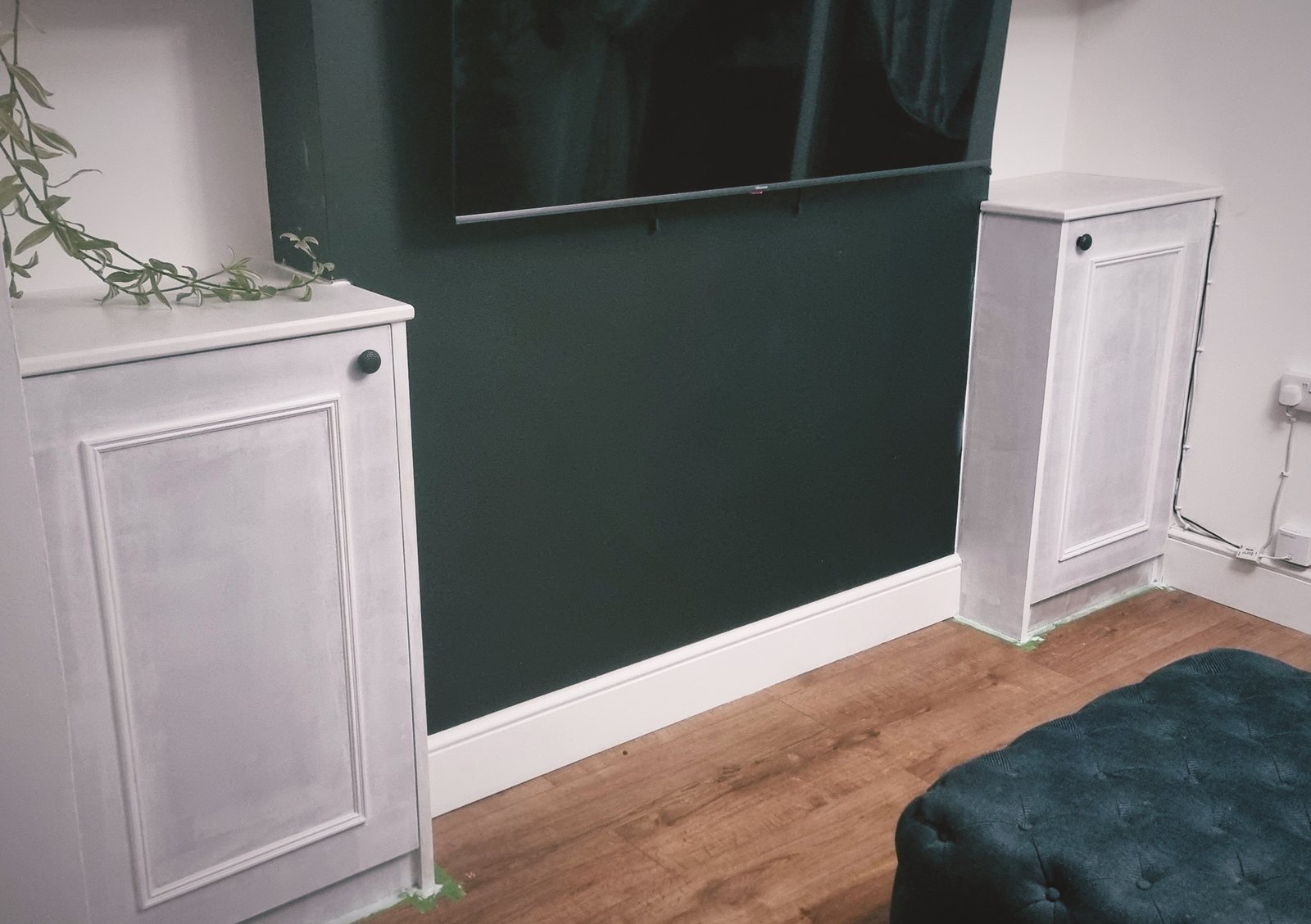 Painted panelled alcove cupboards either side of a TV wall