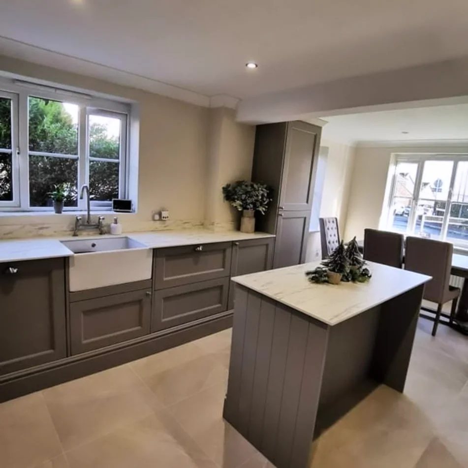 Grey shaker kitchen with a panelled island and white worktops