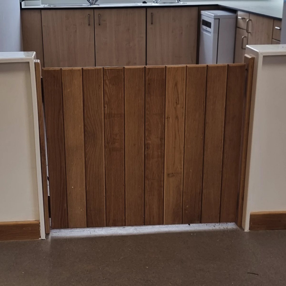 Solid oak boarded gate across a kitchen opening