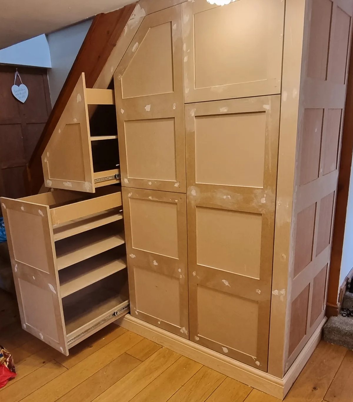 Bespoke under-stairs cupboards with pull-out drawers, before painting